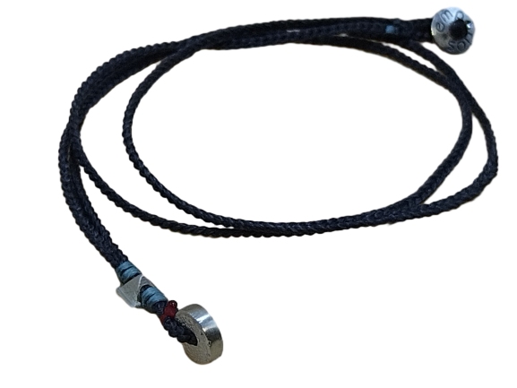 thin cord necklace (multi jewelry) on coal with two geometric beads.